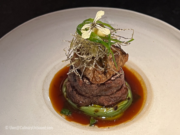 Saddle of lamb and sweetbreads cooked over the embers, elderflower, leek, and yuzu kosho